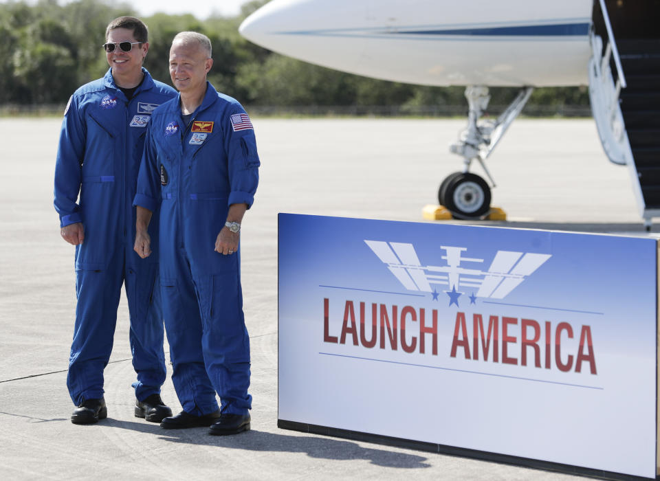 NASA astronauts Robert Behnken, left, and Doug Hurley pose for a photo at a news conference after they arrived at the Kennedy Space Center in Cape Canaveral, Fla., Wednesday, May 20, 2020. The two astronauts will fly on the SpaceX Demo-2 mission to the International Space Station scheduled for launch on May 27. (AP Photo/John Raoux)