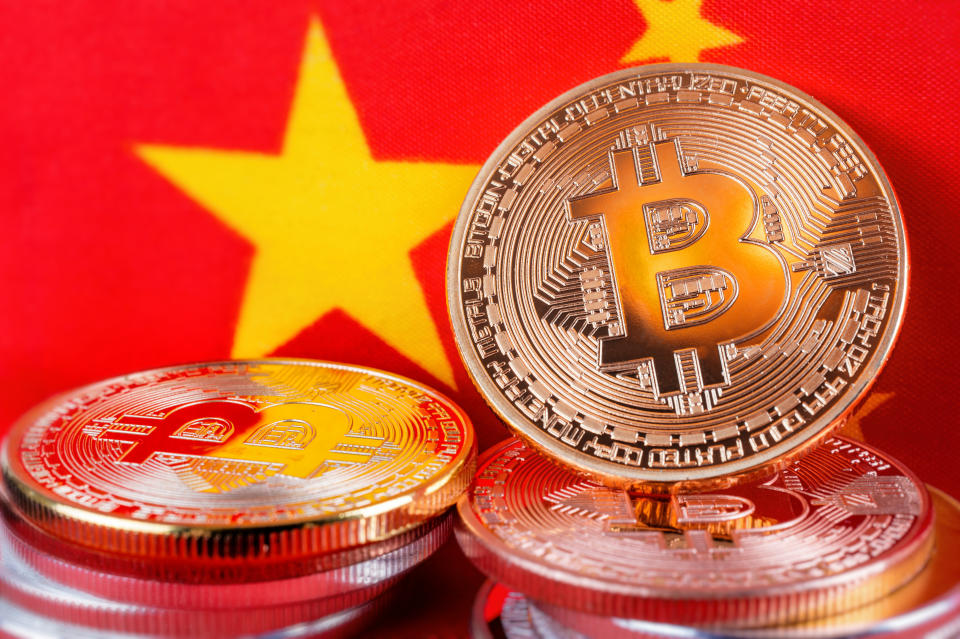 Montreal, 7 May 2018: Bitcoin real coins over chinese flag fabric