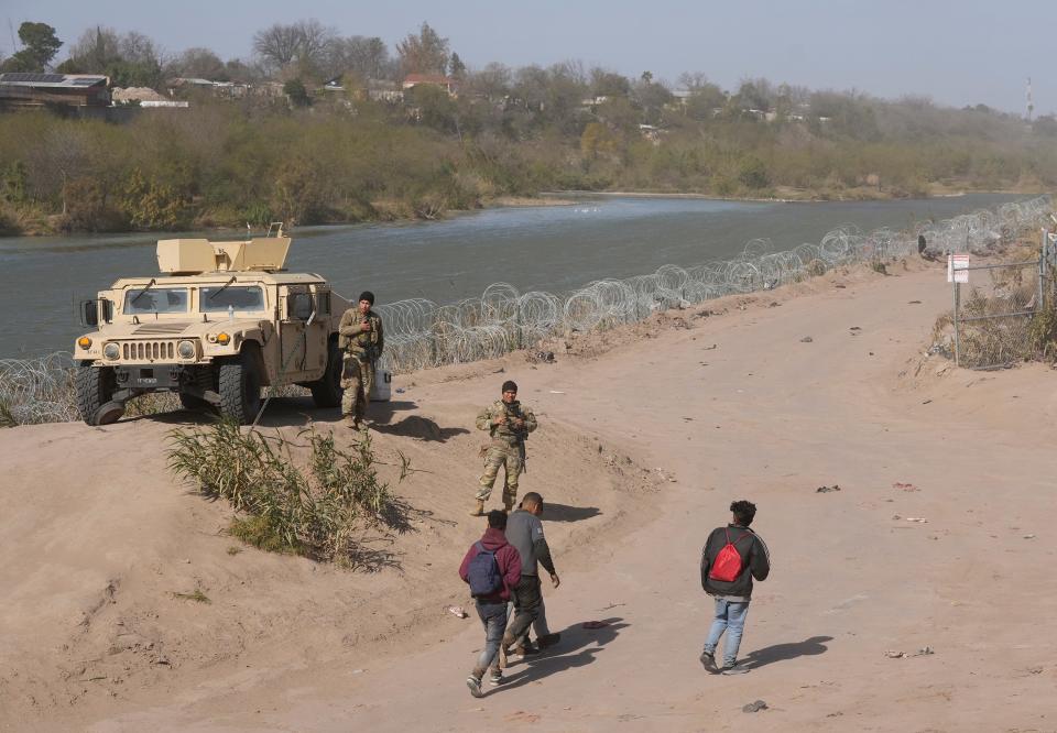 A group of migrants from Venezuela walks along the banks of the Rio Grande to surrender to the U.S. Border Patrol after entering Texas at Eagle Pass on Jan. 8.