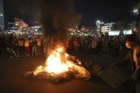 Israelis opposed to Prime Minister Benjamin Netanyahu's judicial overhaul plan set up bonfires and block a highway during a protest moments after the Israeli leader fired his defense minister, in Tel Aviv, Israel, Sunday, March 26, 2023. Defense Minister Yoav Gallant had called on Netanyahu to freeze the plan, citing deep divisions in the country and turmoil in the military. (AP Photo/Oren Ziv)