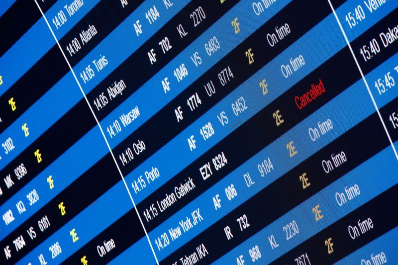 A departures board shows a cancelled flight from Paris to London Gatwick at Paris Charles de Gaulle airport