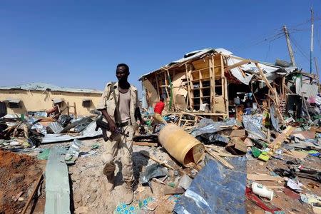 A Somali government soldier walks past the scene of a suicide bomb explosion at the Wadajir market in Madina district of Somalia's capital Mogadishu February 19, 2017. REUTERS/Feisal Omar