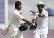 India's Cheteshwar Pujara (L) is congratulated by Sri Lanka's fast bowler Dhammika Prasad for scoring a century during the second day of their third and final test cricket match in Colombo , August 29, 2015. REUTERS/Dinuka Liyanawatte