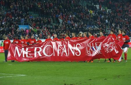 Switzerland's national soccer team players celebrate and hold a banner after defeating San Marino and qualifying for the Euro after their Euro 2016 Group E qualifying soccer match in St. Gallen, Switzerland October 9, 2015. The banner reads : Thank you Fans !. REUTERS/Arnd Wiegmann