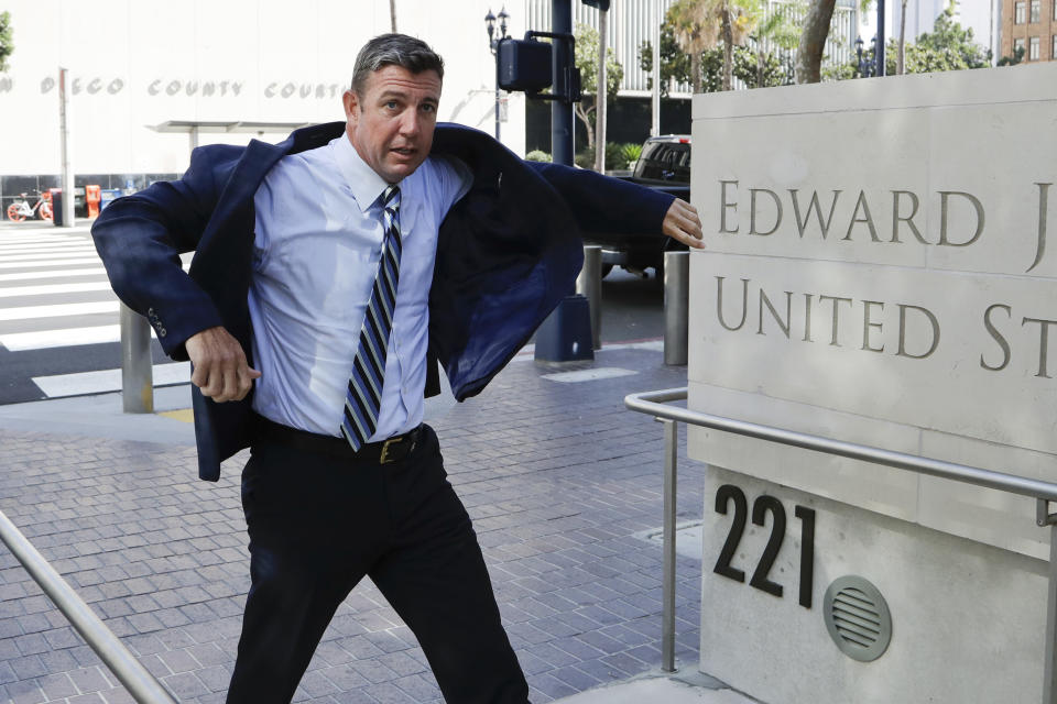 U.S. Rep. Duncan Hunter pulls on his coat as he arrives for an arraignment hearing Thursday, Aug. 23, 2018, in San Diego. Hunter and his wife were indicted on federal charges that they used more than $250,000 in campaign funds for personal expenses that ranged from groceries to golf trips and lied about it in federal filings, prosecutors said. (AP Photo/Gregory Bull)