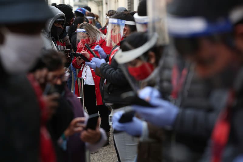 IMAGEN DE ARCHIVO. Trabajadores de una Administradora de Fondos de Pensiones utilizando protectores faciales ayudan a clientes a realizar el trámite para retirar un 10% de sus ahorros previsionales, en medio del brote de coronavirus, en Santiafgo, Chile,