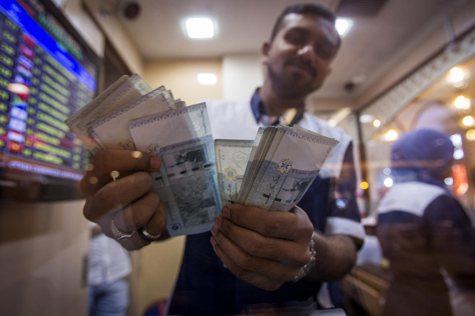A currency trader holds up Malaysian ringgit notes at a currency exchange store in Kuala Lumpur, Malaysia on Tuesday, March 17, 2015. The Malaysian ringgit Tuesday closed at 3.69 against the US dollar. (AP Photo/Joshua Paul)