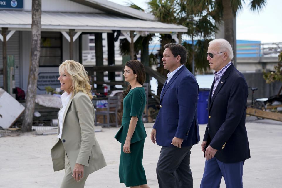 President Joe Biden, right, and first lady Jill Biden, left, tour an area impacted by Hurricane Ian with Florida Gov. Ron DeSantis, second from right, and his wife Casey DeSantis on Wednesday, Oct. 5, 2022, in Fort Myers Beach, Fla. (AP Photo/Evan Vucci)