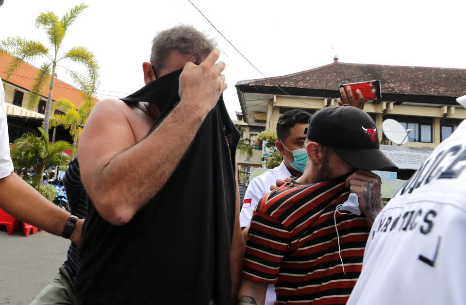 Police officers escort Australian national Aaron Wayne Coyle, left, and British national Collum Park, center, at the regional police headquarters in Denpasar, Indonesia on Thursday, Sept. 3, 2020. Indonesian police say the men have been arrested with methamphetamine and ecstasy drugs on the tourist island of Bali. (AP Photo/Firdia Lisnawati)