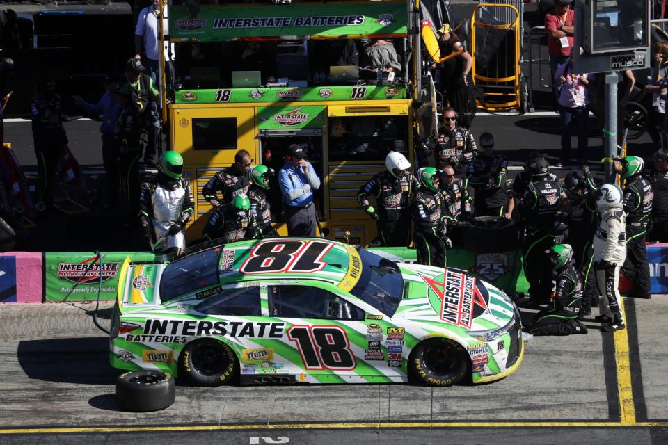 Kyle Busch's team fixes the left front of his car on Sunday. (Getty)