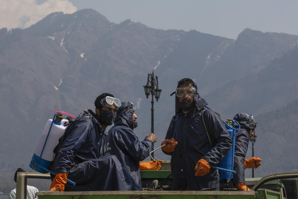 Srinagar Municipal Corporation staff travel in a vehicle after spraying disinfectants in a tourist area as a precautionary measure against COVID-19 in Srinagar, Indian controlled Kashmir, March 18, 2020. (AP Photo/ Dar Yasin)