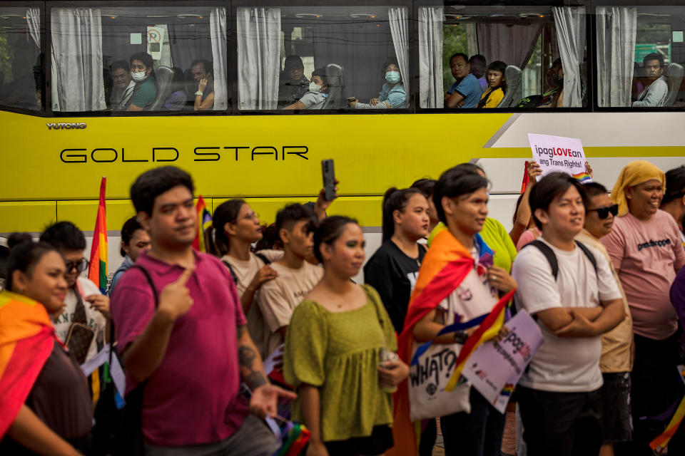 Commuters look on from a bus at activists taking part in a protest to kick off Pride month in Quezon City on June 2.<span class="copyright">Ezra Acayan—Getty Images</span>