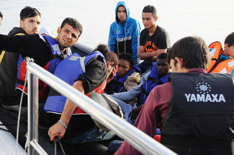 Men and women, exhausted from lengthy and perilous journeys, wait to find out whether they will be rescued or not.