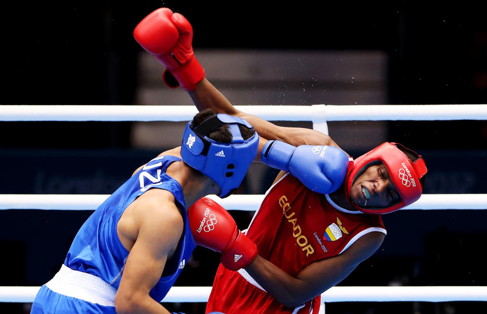 LONDON, ENGLAND - JULY 31: Anderson Mina Rojas of Equador (R) in action with Uktamjon Rahmonov of Uzbekistan during the Men's Light Welter (64kg) Boxing on Day 4 of the London 2012 Olympic Games at ExCeL on July 31, 2012 in London, England. (Photo by Scott Heavey/Getty Images)