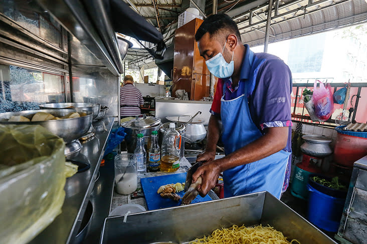 Muhamad Faris preparing the ingredients for 'mee manja' at the stall.