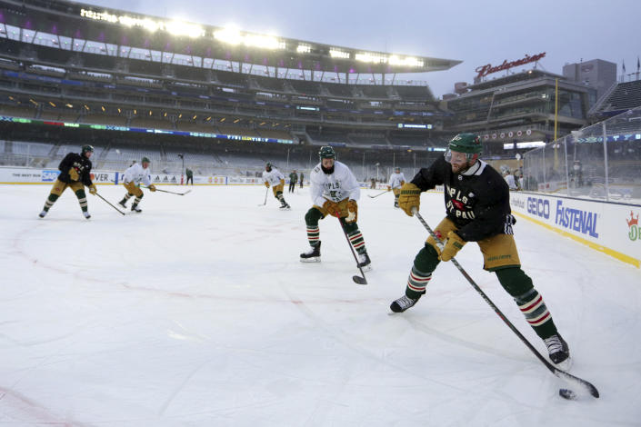 Minnesota Wild defenseman Alex Goligoski (47) controls the puck in front of center Nico Sturm (7) during practice at Target Field in Minneapolis on Friday, Dec. 31, 2021, for Saturday's NHL Winter Classic against the St. Louis Blues. (AP Photo/Andy Clayton-King)