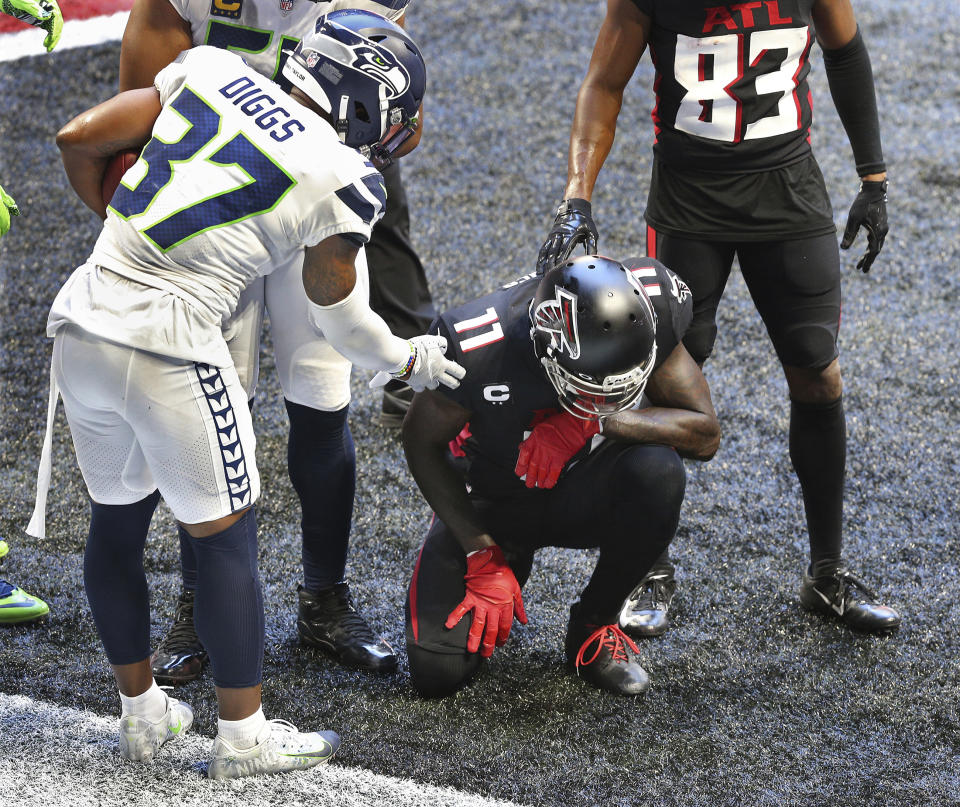 Seattle Seahawks free safety Quandre Diggs, left, consoles Atlanta Falcons wide receiver Julio Jones in the end zone after intercepting a Falcons pass during an NFL football game Sunday, Sept. 13, 2020, in Atlanta. (Curtis Compton/Atlanta Journal-Constitution via AP)