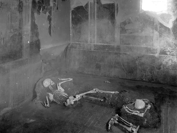 The two individuals, a man and a woman, laying as they died in the House of the Craftsman.