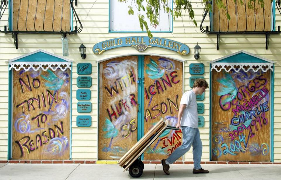 Jeff Naset hauls a load of plywood along Duval Street on Sept. 10, 2004, as he helps his family board up the Birkenstock of Old Town Footwear store in Key West, in anticipation of the arrival of Hurricane Ivan.