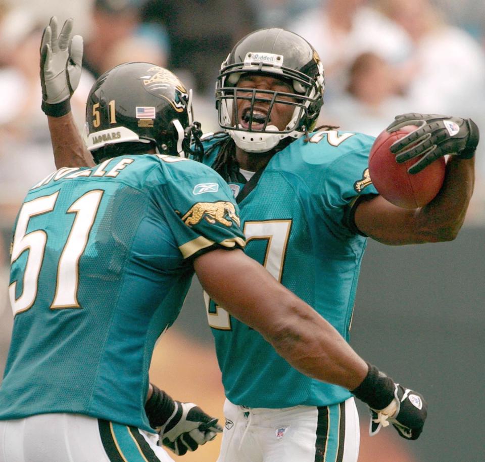 Jacksonville Jaguars safety Rashean Mathis (No. 27) jumps into the arms of linebacker Akin Ayodele celebrating his first NFL career interception in the fourth quarter against the Carolina Panthers at Ericsson Stadium in Charlotte, N.C., on Sunday, September 7, 2003. [Rick Wilson/The Florida Times-Union]
