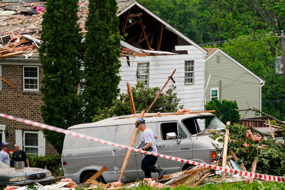 An investigator moves through the scene of a deadly explosion in a residential neighborhood in Pottstown, Pa., Friday, May 27, 2022. A house exploded northwest of Philadelphia, killing several people and leaving others injured, authorities said Friday. (AP Photo/Matt Rourke)