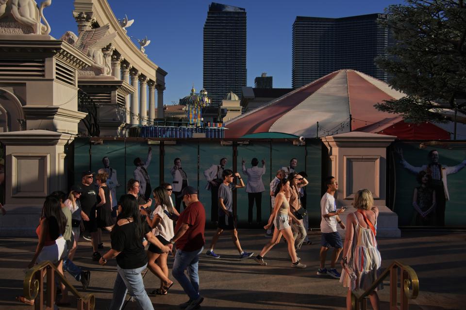 FILE - People shield their eyes from the sun along the Las Vegas Strip, Sunday, July 7, 2024, in Las Vegas. Used to shrugging off the heat, Las Vegas residents are now eyeing the thermometer as the desert city is on track Wednesday to set a record for the most consecutive days over 115 degrees (46.1 C) amid a lingering hot spell that's expected to continue scorching much of the U.S. into the weekend. (AP Photo/John Locher, File)