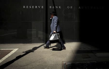 A Sydney businessman walks into the light outside the Reserve Bank of Australia (RBA), in this February 3, 2015 file photo. REUTERS/Jason Reed