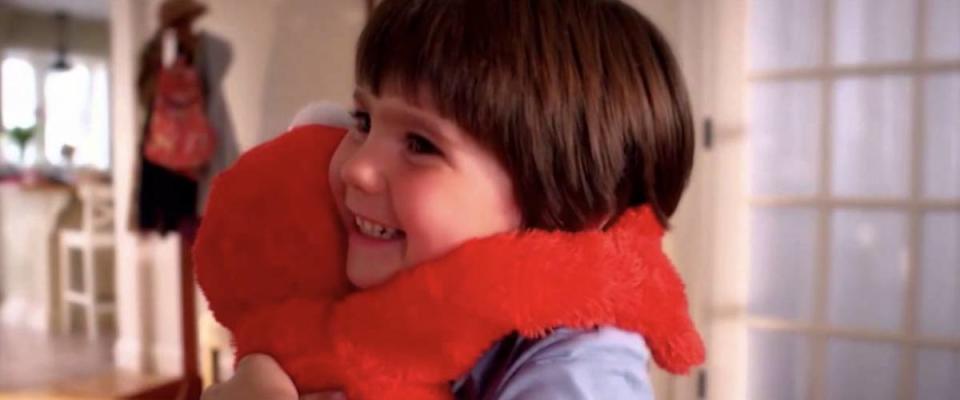 Child hugs an Elmo doll