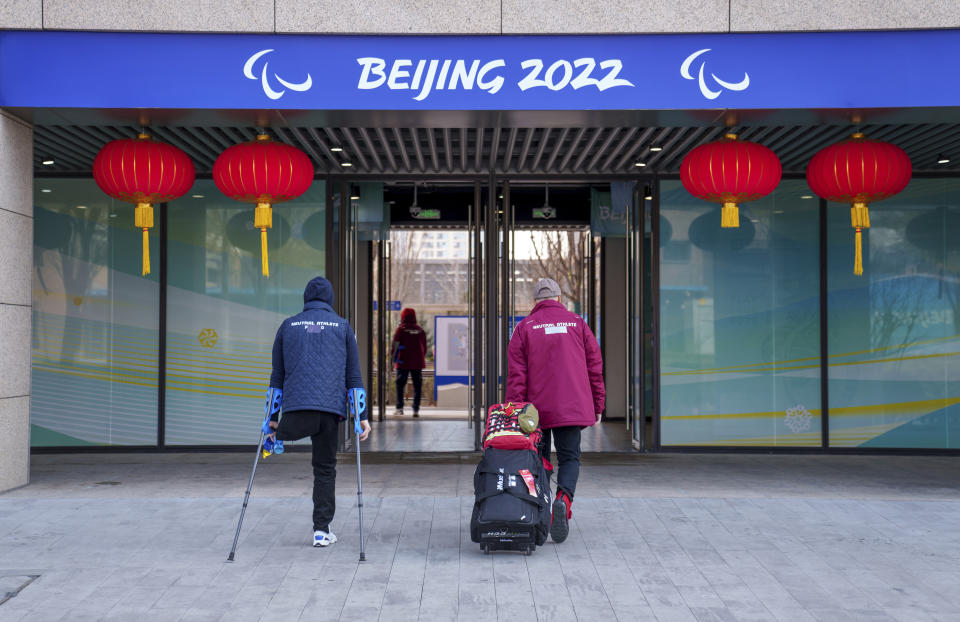 Neutral athletes with re-branded clothing arrive at the Paralympic Village. Tape is seen covering the word 'Russia' on the back of an athlete's jacket as a result of the announcement on Wednesday March 2, 2022, that athletes from the Russian Paralympic Committee and Belarus would be competing as neutrals under the Paralympic flag. Beijing 2022 Winter Paralympic Games, Beijing, China, Thursday 03 March 2022. (Thomas Lovelock/OIS via AP)