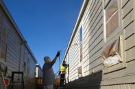 Workers paint buildings in a newly constructed man camp outside of Midland