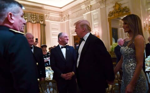 President Donald Trump and first lady Melania Trump walk into the State Dining Room to attend a State Dinner  - Credit: AP