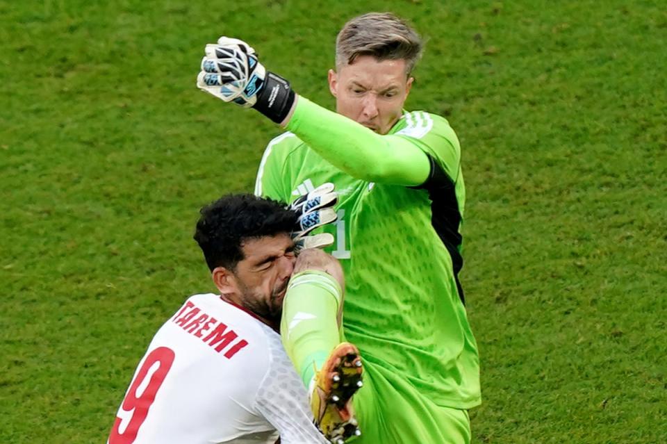 Seeing red: Wayne Hennessey clatters into Mehdi Taremi in a huge blunder as Wales fall to Iran at World Cup (PA)