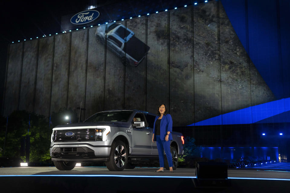 In a photo provided by Ford, Linda Zhang, F-150 Lightning chief engineer, explains details of Ford's first all-electric truck at the reveal of the vehicle at Ford headquarters in Dearborn, Mich., Wednesday, May 19, 2021. the pickup will be able to travel up to 300 miles per battery charge, thanks to a frame designed to safely hold a huge lithium-ion battery that can power your house should the electricity go out. Going from zero to 60 mph (97 kilometers per hour) will take just 4.5 seconds. (Eric Perry/Ford via AP)