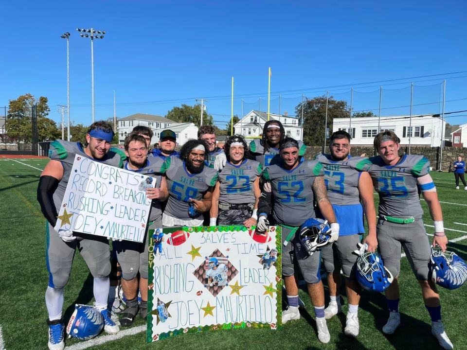 Senior running back Joey Mauriello (23) is flanked by his teammates after breaking Salve Regina's all-time rushing record previously held by Jim Callahan on Saturday, Oct. 16, 2022.