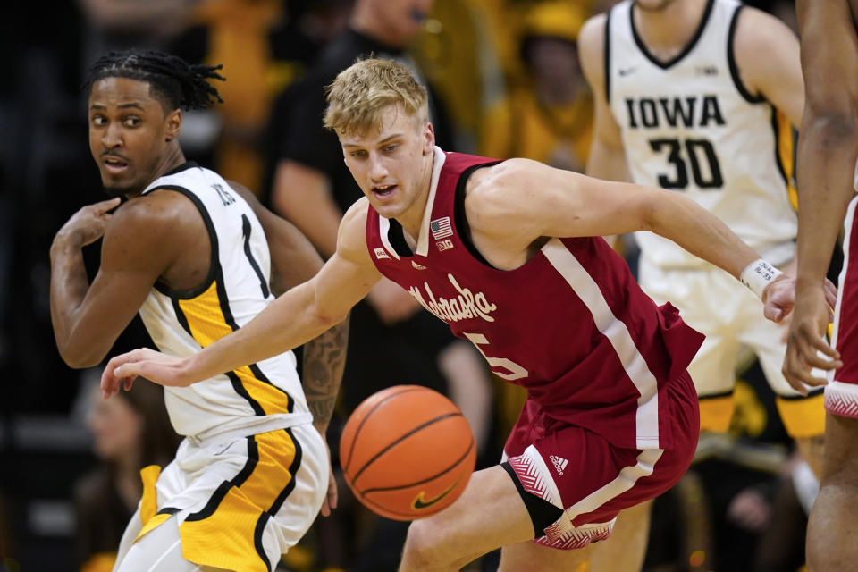Nebraska guard Sam Griesel (5) fights for a loose ball with Iowa guard Ahron Ulis, left, during the second half of an NCAA college basketball game, Sunday, March 5, 2023, in Iowa City, Iowa. Nebraska won 81-77. (AP Photo/Charlie Neibergall)
