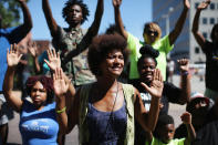 <p>Demonstrators raise their hands and chant “hands up, don’t shoot” during a protest over the killing of Michael Brown on August 12, 2014 in Clayton, Missouri. Some reports state that Brown hand his hands in the air when he was shot and killed by a police officer on Saturday in suburban Ferguson, Missouri. Two days of unrest including rioting and looting have followed the shooting in Ferguson. Browns parents have publicly asked for order. (Scott Olson/Getty Images) </p>