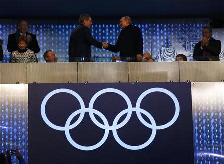 President of Russia, Vladimir Putin (R) shakes hands with International Olympic Committee President Thomas Bach, as Secretary-General of the United Nations Ban Ki-moon looks on during the opening ceremony of the 2014 Sochi Winter Olympics, February 7, 2014. REUTERS/Brian Snyder