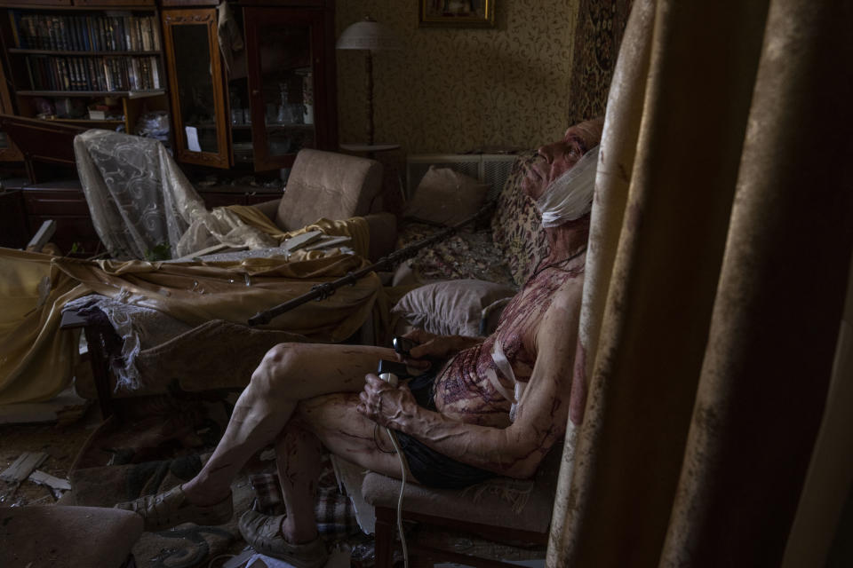 Sixty-six-year-old Volodymyr, injured from a strike, sits on a chair in his damaged apartment, in Kramatorsk, Donetsk region, eastern Ukraine, Thursday, July 7, 2022. (AP Photo/Nariman El-Mofty)