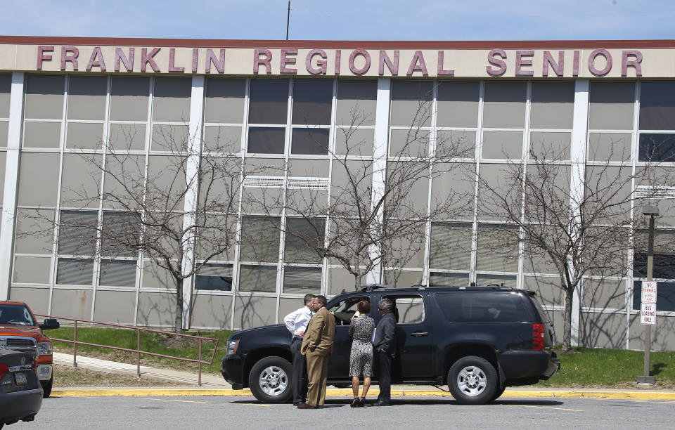 A group of reporters talks with a deputy from the Westmoreland County department of public safety in his vehicle at Franklin Regional High School near Pittsburgh, on Thursday, April 10, 2014 in Murrysville, Pa. A knife wielding student injured over 20 people in a stabbing attack there on April 9. Authorities have charged Alex Hribal, 16, with four counts of attempted homicide and 21 counts of aggravated assault in the attack. (AP Photo/Keith Srakocic)