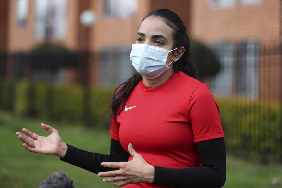 Wearing a face mask, Venezuelan soccer player María Alejandra Peraza, who played last season with Colombia's Millonarios women's team, speaks during an interview in Bogota, Colombia, Thursday, May 21, 2020. Peraza is one of hundreds of professional female players who have received a food package from the Ministry of Sport in Colombia during the lockdown to curb the COVID-19. (AP Photo/Fernando Vergara)