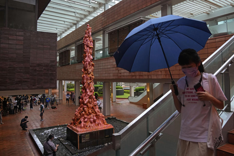 A woman walks in front of the "Pillar of Shame" statue, a memorial for those killed in the 1989 Tiananmen crackdown, at the University of Hong Kong, Wednesday, Oct. 13, 2021. Danish artist Jens Galschioet is seeking to get back his sculpture in Hong Kong memorializing the victims of China's 1989 Tiananmen Square crackdown as a deadline loomed for its removal Wednesday. (AP Photo/Kin Cheung)