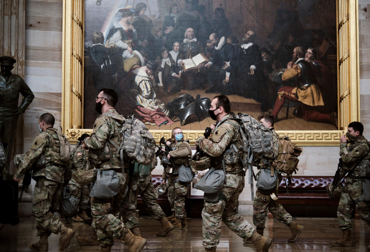 Armed National Guard troops gather in the rotunda of the Capitol in Washington on Jan. 13, 2021.