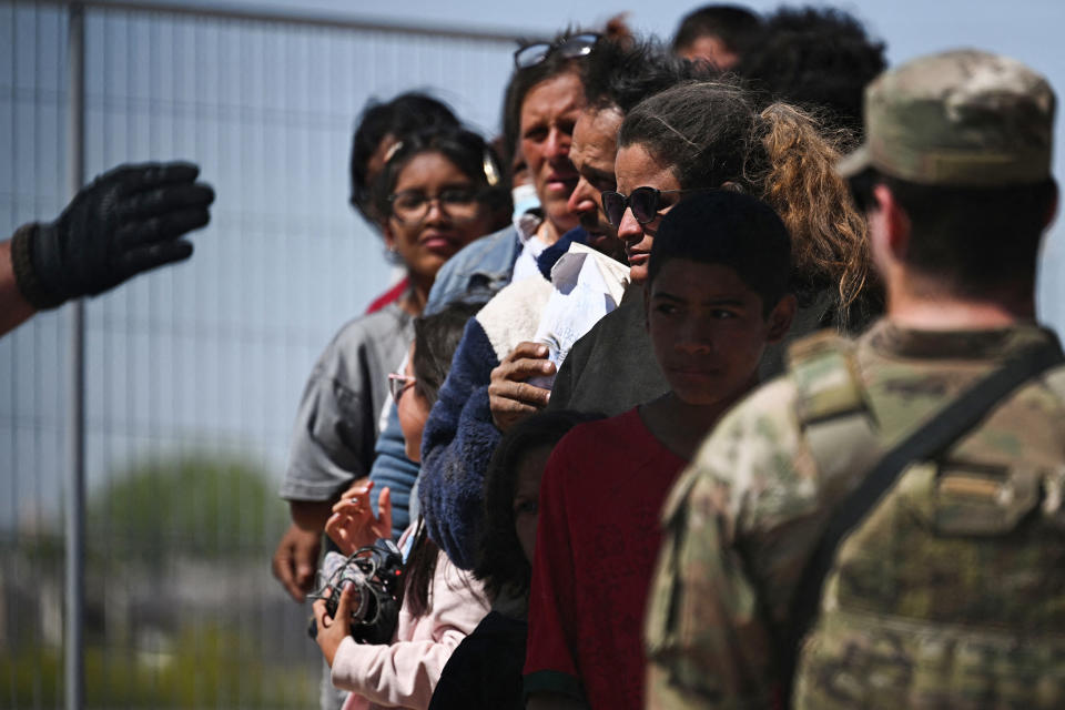 A member of the Texas Army National Guard watches as U.S. Customs and Border Protection Border Patrol agents search migrants surrendering themselves for the processing of immigration and asylum claims on the U.S.-Mexico border in El Paso, Texas on May 10, 2023.  (Patrick T. Fallon / AFP via Getty Images)