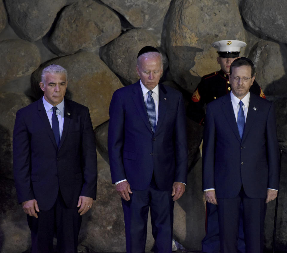 From left, Israeli Prime Minister Yair Lapid, U.S. President Joe Biden and Israeli President Isaac Herzog attend a memorial ceremony at the Hall of Remembrance of the Yad Vashem Holocaust Memorial Museum in Jerusalem, Wednesday, July 13, 2022. (Debbie Hill/Pool via AP)