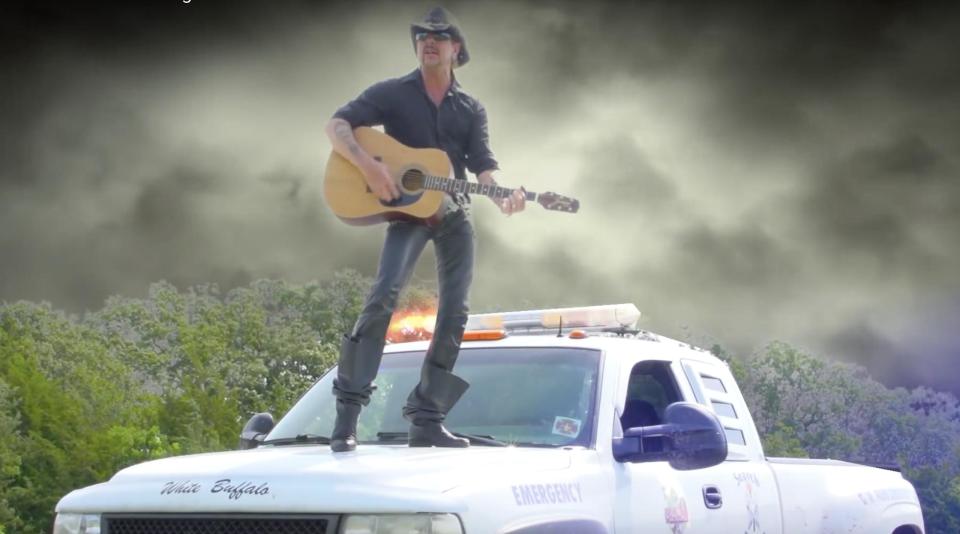 Joe Exotic stands on top of a pickup truck in the music video for "I Saw a Tiger."