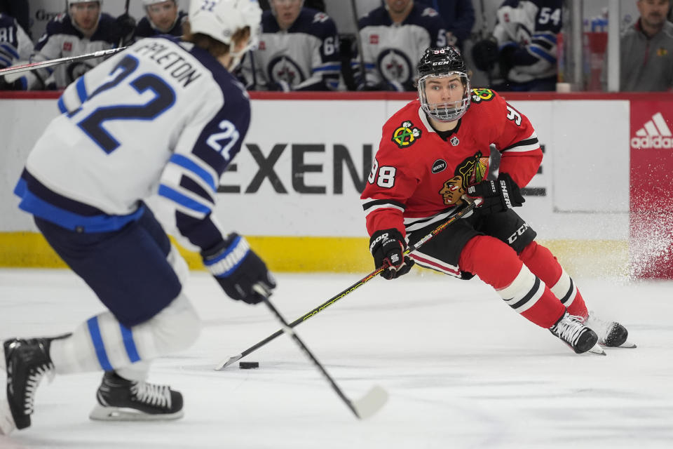 Chicago Blackhawks center Connor Bedard, right, handles the puck during the second period of an NHL hockey game against the Winnipeg Jets, Friday, Feb. 23, 2024, in Chicago. (AP Photo/Erin Hooley)