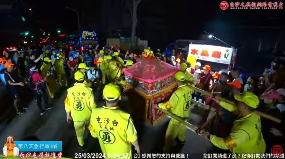 白沙屯媽祖在北返路途中，遇到一名年輕爸爸抱著嬰兒跪地祈願（箭頭處），突然後退停下。翻攝「白沙屯媽祖網路電視台」YouTube