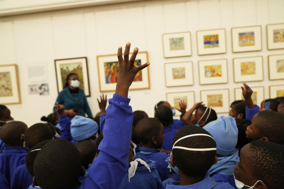 Schoolchildren look at paintings done in the 1940s and 1950s by young Black students at Cyrene Mission School at the National Gallery of Zimbabwe, Wednesday Aug. 3, 2022. The paintings are part of a historic exhibit, "The Stars are Bright," now showing in Zimbabwe for the first time since the collection left the country more than 70 years ago. (AP Photo/Tsvangirayi Mukwazhi)