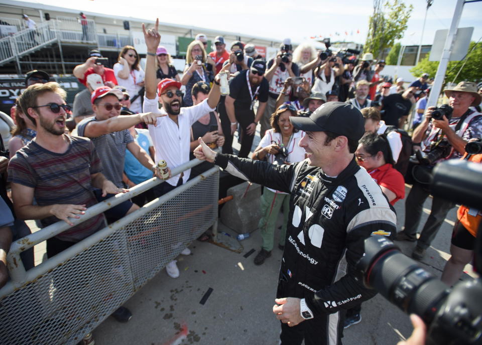 Simon Pagenaud, right, of France, celebrates with fans after winning the Honda Indy auto race in Toronto, Sunday, July 14, 2019. (Andrew Lahodynskyj/The Canadian Press via AP)