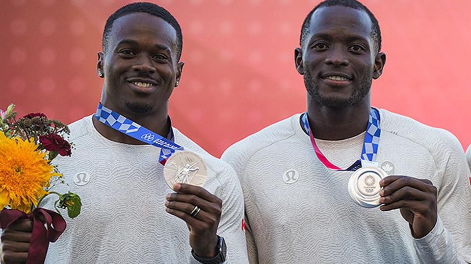 From left: Canadian sprinters Aaron Brown and Jerome Blake pose with their upgraded relay silver medals from the 2021 Tokyo Olympics. For some time, Brown believes he, his relay teammates and athletes from all sports should be paid for appearing in a final race at the Summer Games.  (Darryl Dyck/Canadian Press/File - image credit)